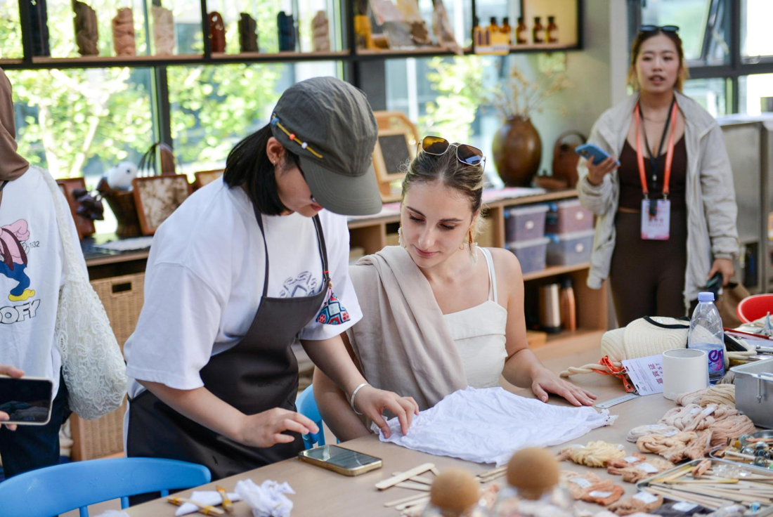 A visitor learning a plant dyeing activity with an instructor