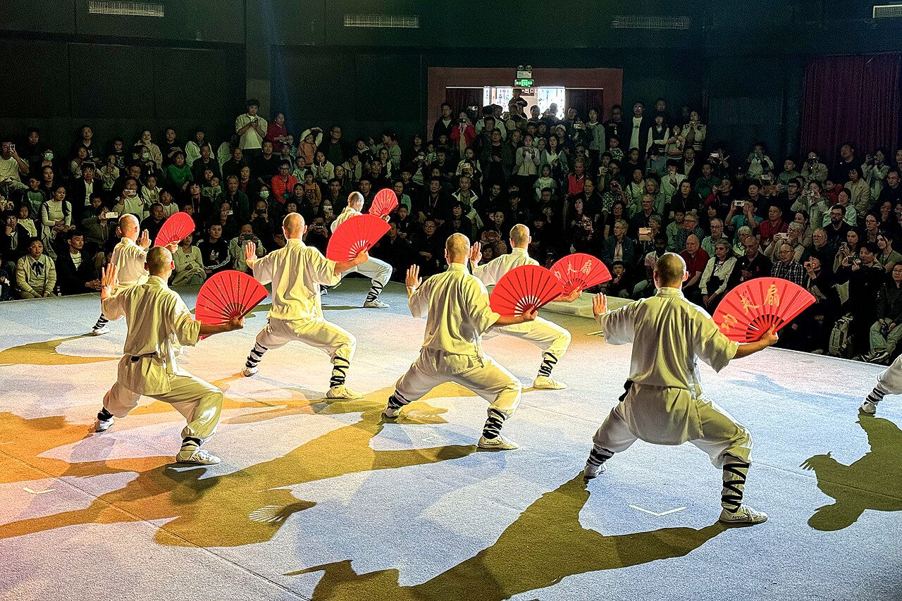 Shaolin martial artists performing a fan form in Dengfeng